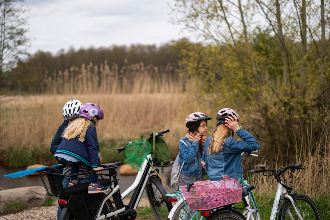 Fahrradfahrende setzen ihre Helme auf, um ihre Radtour fortzusetzen.