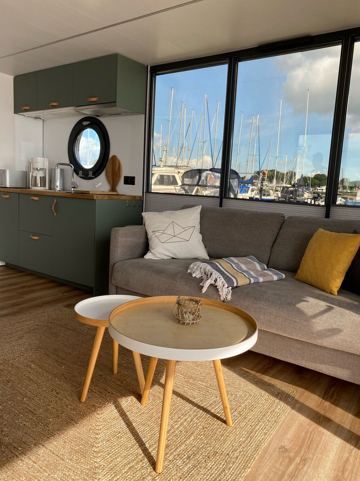 Eine kleine Küchenzeile, ein Sofa und zwei kleine Tische auf einem Hausboot